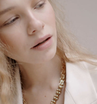 “gold chunky chain necklace worn by woman – close-up