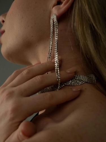 long rhinestone drop earrings and matching rhinestone choker on model’s neck