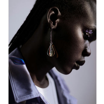 teardrop-shaped glass earring on model’s ear close-up