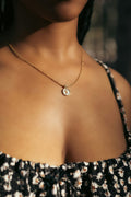 

gold pendant necklace on model’s neck close-up